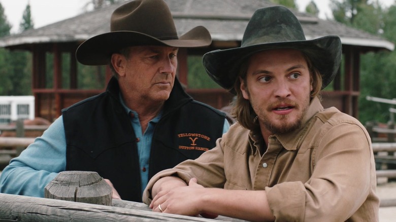 John and Kacey Dutton lean on a wooden fence in "Yellowstone" (2018-2024)