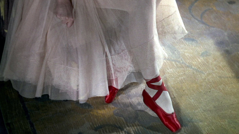 a ballerina wearing red shoes