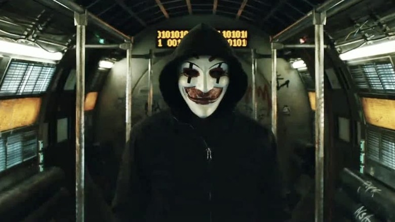 A masked man standing in an empty train car