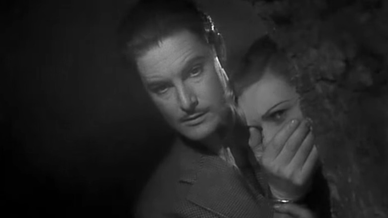 Man puts hand over woman's mouth