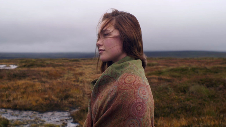 Florence Pugh as Katharine standing in a field wrapped in a blanket in Lady Macbeth (2016)