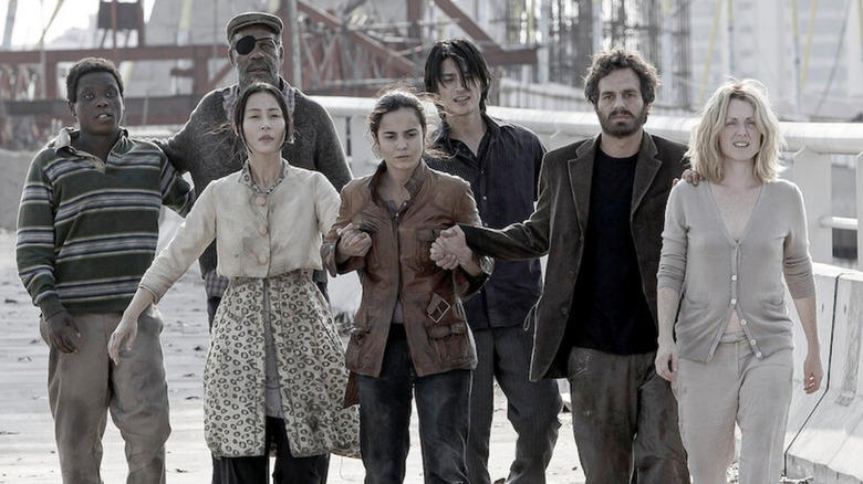 A group of survivors walking together across a bridge in "Blindness"