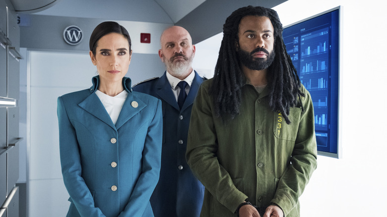 Melanie and Sam escorting Andre Layton in Snowpiercer (2020)