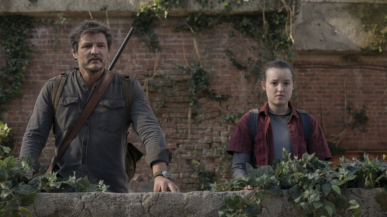 Joel and Ellie standing near a brick ledge in The Last of Us (2023)