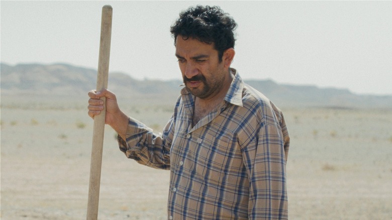 Vahid standing outside holding a long handle in It Was Just an Accident