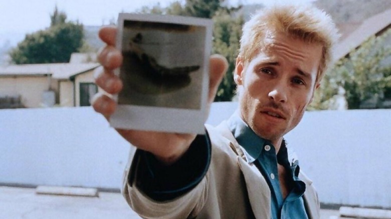 Leonard Shelby holding a polaroid of a body in the movie Memento