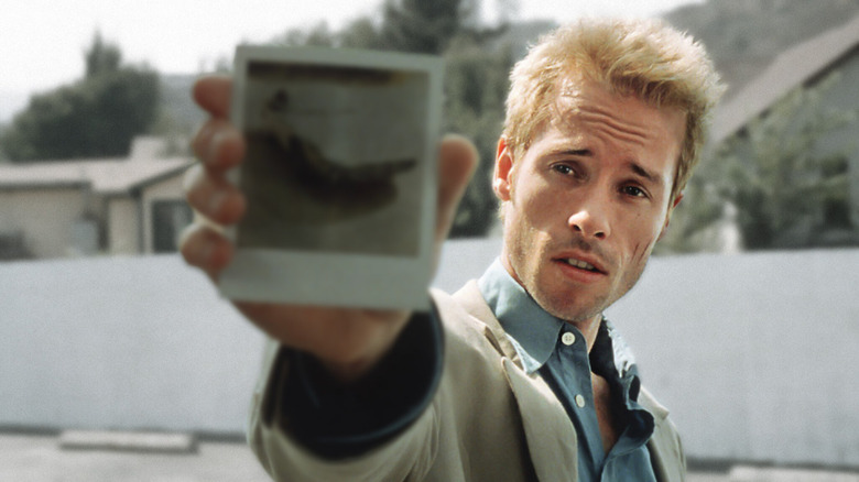 Leonard Shelby shows someone a photo in "Memento" (2000)