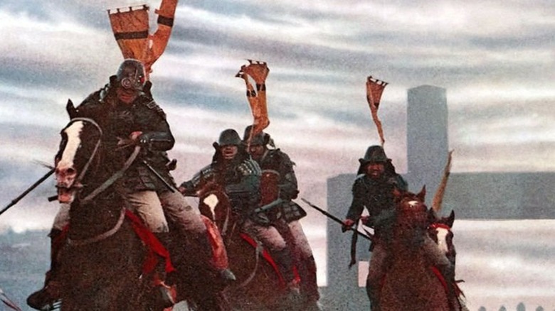 Armored samurai warriors riding on horseback in a battle in Ran