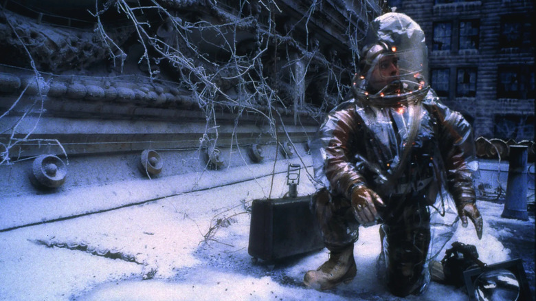 James Cole wears a plastic space suit with glowing yellow lights in a post-apocalyptic city in "12 Monkeys" (1995)