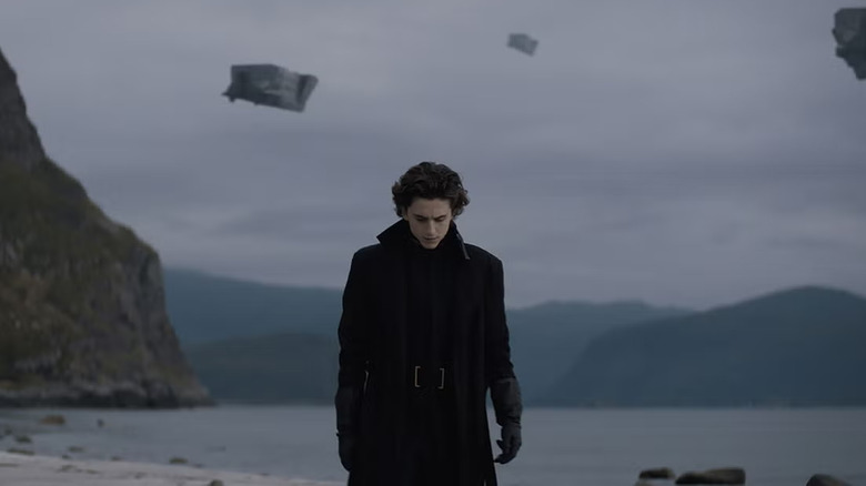 Paul Atreides walks along the beach as spaceships fly behind him in "Dune" (2021)