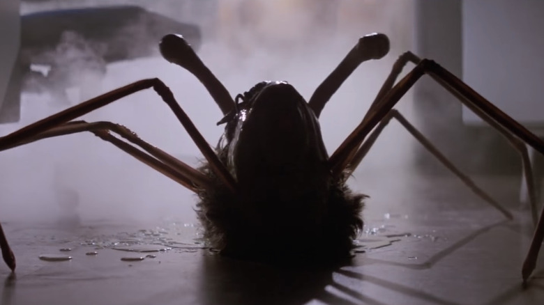 A human head with snail-like eyes and spider legs crawls across the floor in "The Thing" (1982)