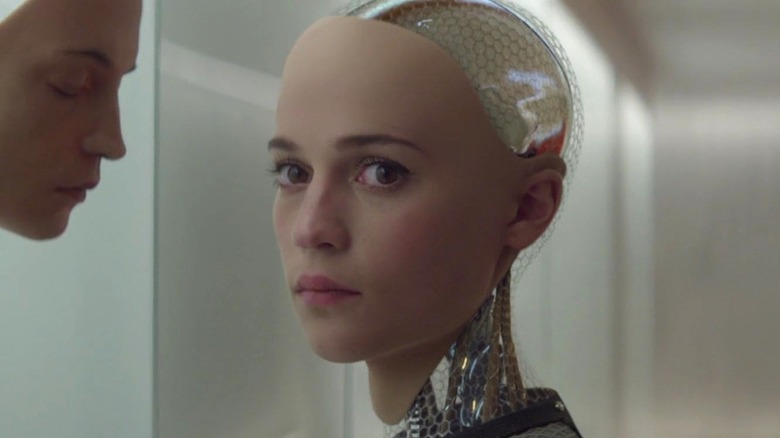 Ava standing in front of mask looking to the side in 'Ex Machina' (2014)