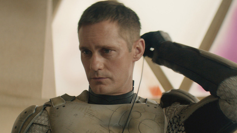 Murderbot plugging something into his head in Murderbot (2025)