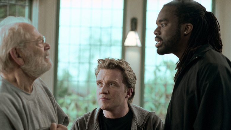 Bruce talks to an elderly man as Johnny looks on in The Dead Zone (2002)