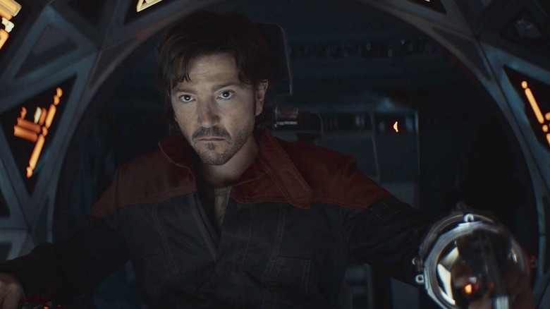 Cassian Andor sitting in a dark, compact cockpit piloting his ship