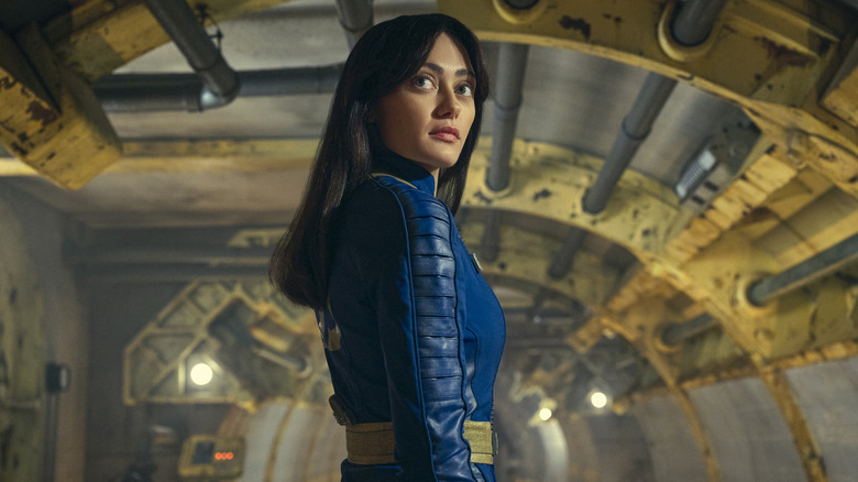 Lucy MacLean turning around in a Vault suit to look behind her in Fallout (2024)