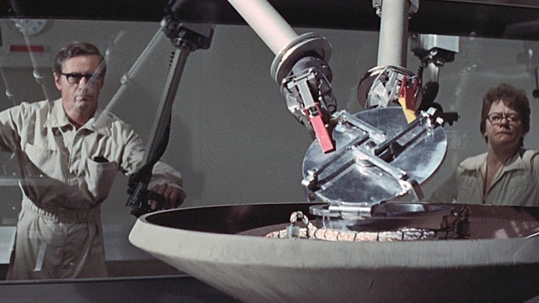 Scientists operate mechanical arms through glass in "The Andromeda Strain" (1971)