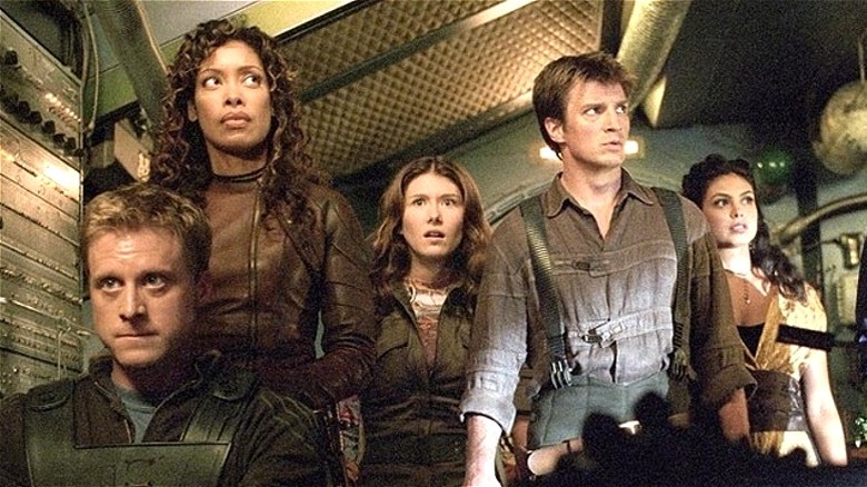 Mal, Kaylee, Zoë, Wash, and Inara gathered together in ship in Serenity (2005)