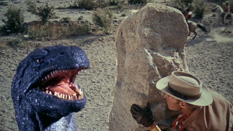A cowboy hiding behind a rock from Gwangi in The Valley of Gwangi (1969)