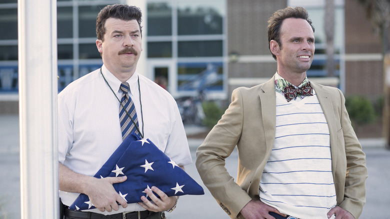 Neal Gamby holding a folded American flag next to fellow vice principal Lee Russell in Vice Principals