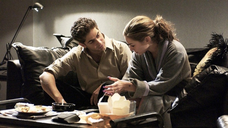 Christopher and Adriana sit on couch