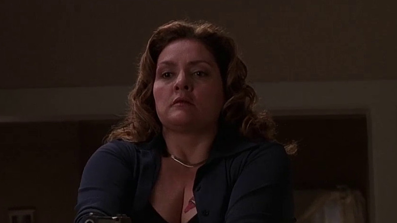 Janice stands in dark room