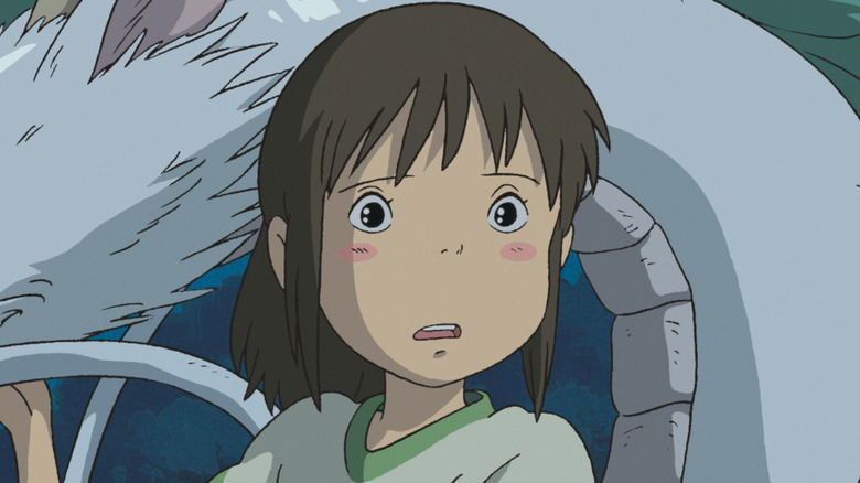 Haku kneels by a dragon in Spirited Away