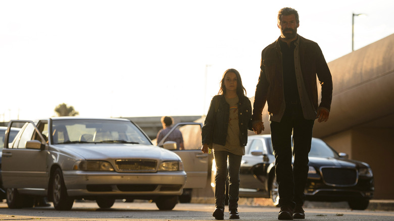 Logan and Laura walking hand-in-hand in Logan (2017)