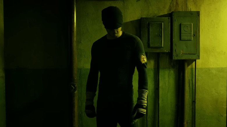 Daredevil standing in a dark hallway