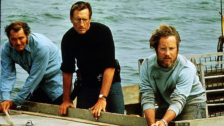 Hooper, Brody and Quint leaning over the side of a boat