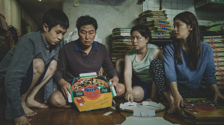 Kim Ki-taek and his family folding pizza boxes on floor in "Parasite" (2019)