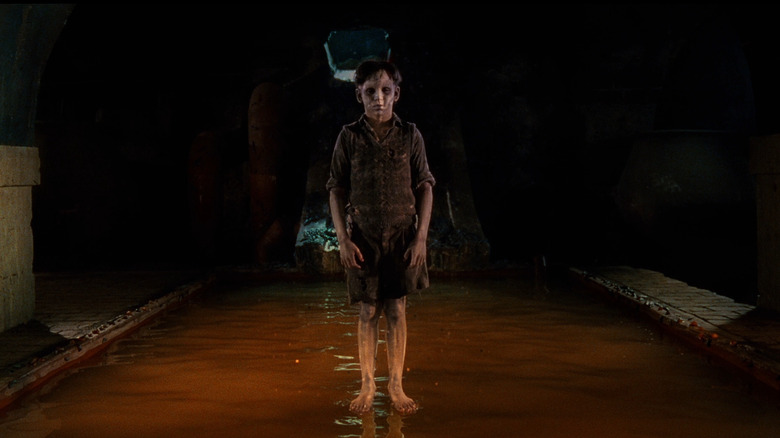 Ghoulish boy stands in water