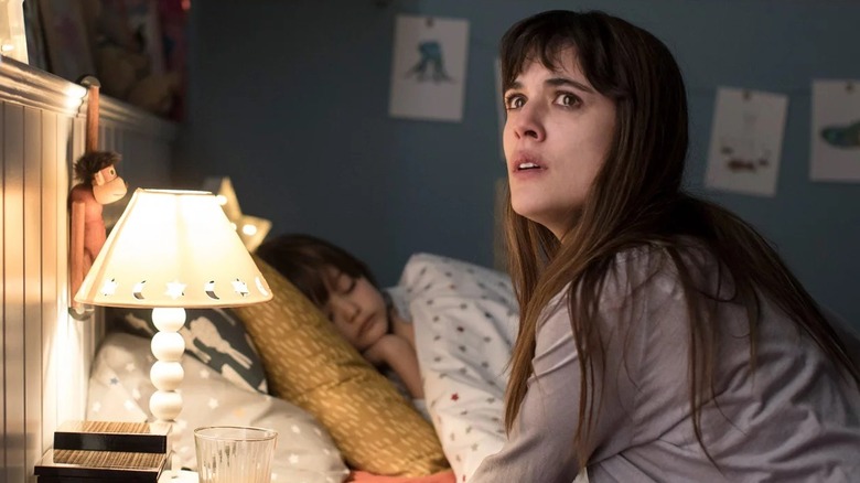 Vera sitting next to her child in bed in "Mirage" (2018)