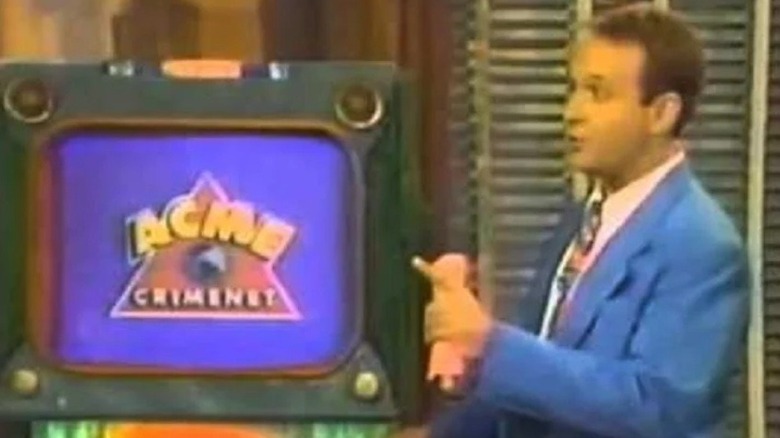 Greg Lee points to a TV monitor on "Where in the World is Carmen Sandiego?" (1991-1995)