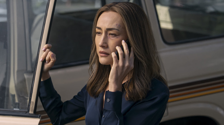 Ballard on the phone holding open a car door in Ballard (2025)