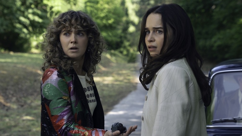 Bea and Twila standing on a road next to a car in "PONIES"