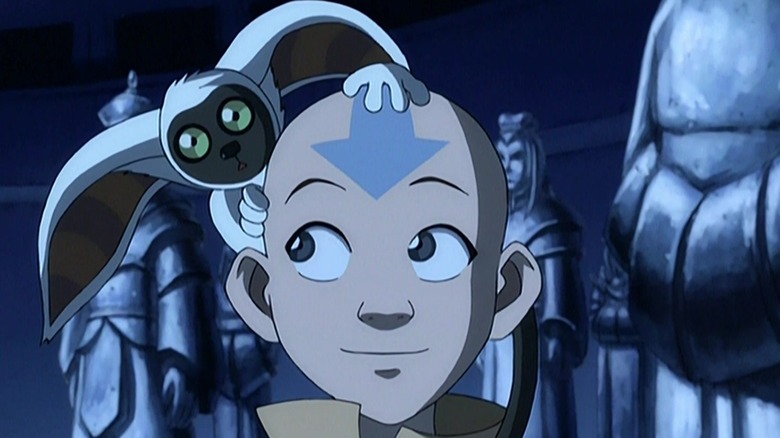 Momo holds onto Aang's head in a statue filled chamber in "Avatar: The Last Airbender"