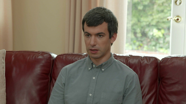 Nathan Fielder sits on a coach with a blank expression in "Nathan For You"