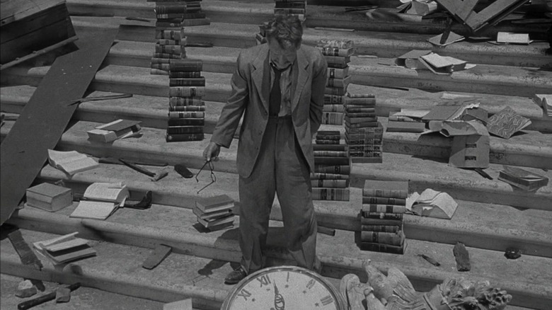 Henry Bemis stands on steps amidst piles of books and debris in "The Twilight Zone"