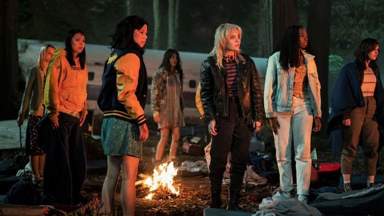 The Yellowjackets stand around a fire by the crashed plane in "Yellowjackets"