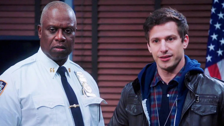 Captain Raymond Holt and Detective Jake Peralta standing next to each other in the precinct in "Brooklyn Nine-Nine"