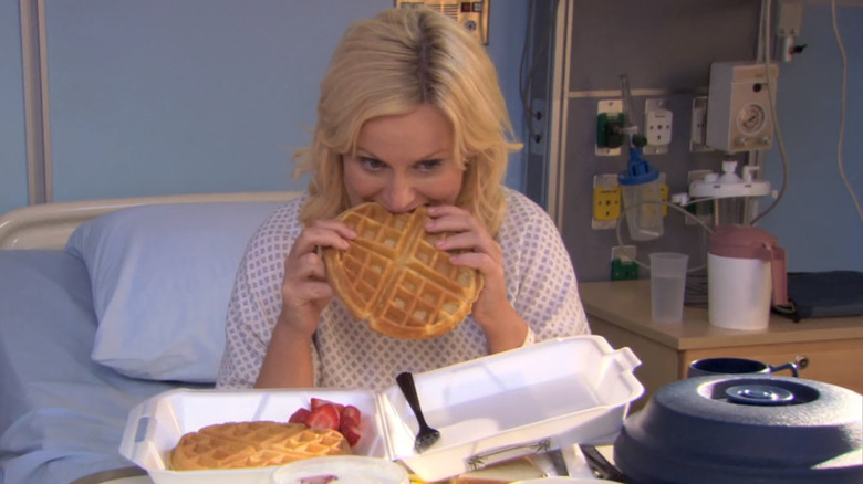 Leslie Knope eating waffles while recovering in a hospital bed