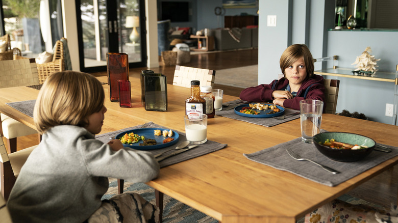 Josh and Max sitting across from each other at a dinner table in Big Little Lies