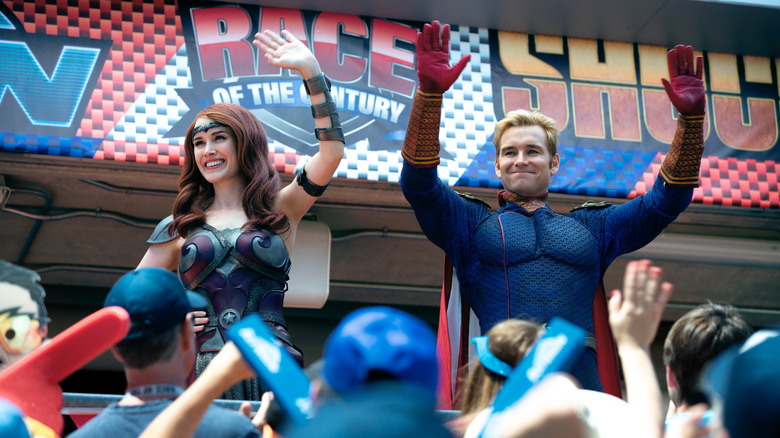 Homelander and Queen Maeve wave at the crowds