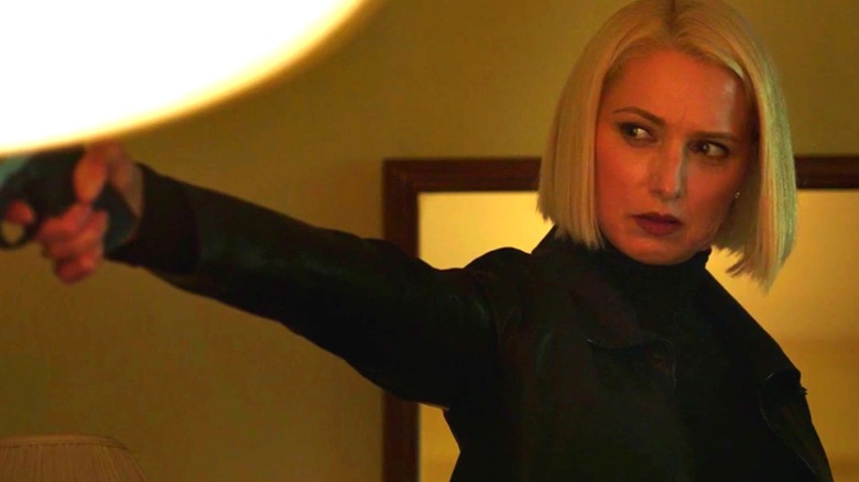 Sally holding a gun up to someone just out of frame in Imposters (2017)