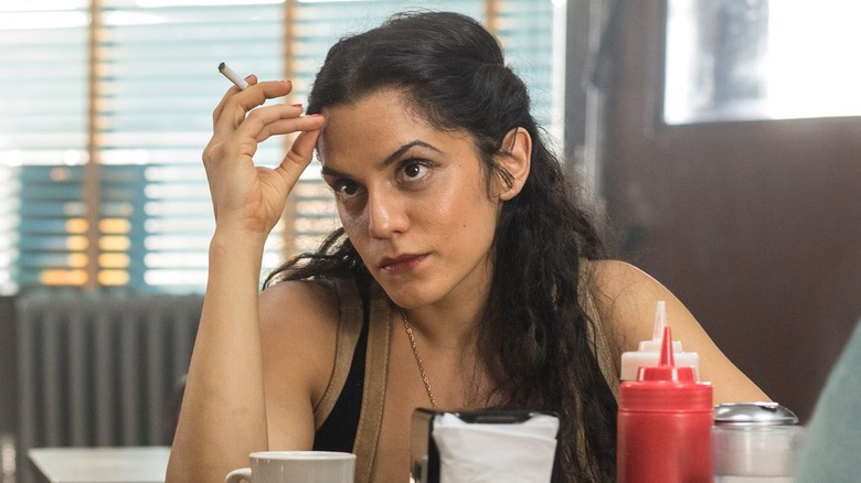 Loretta sitting in a restaurant holding a cigarette in The Deuce (2017)