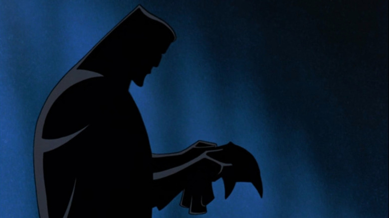 Silhouetted Bruce Wayne putting on the Batman suit in Batman: Mask of the Phantasm