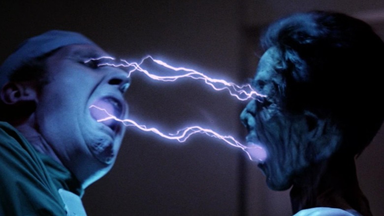 A desiccated vampire sucking energy from a screaming doctor in Lifeforce