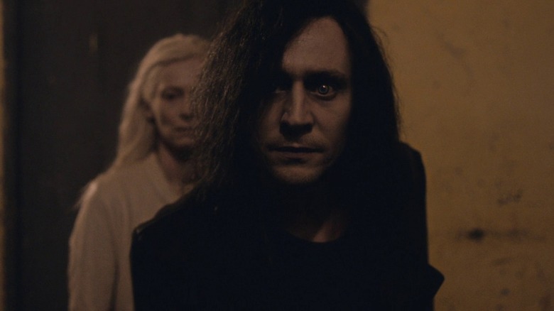 Adam staring forward while Eve lurks in the alley behind him in Only Lovers Left Alive