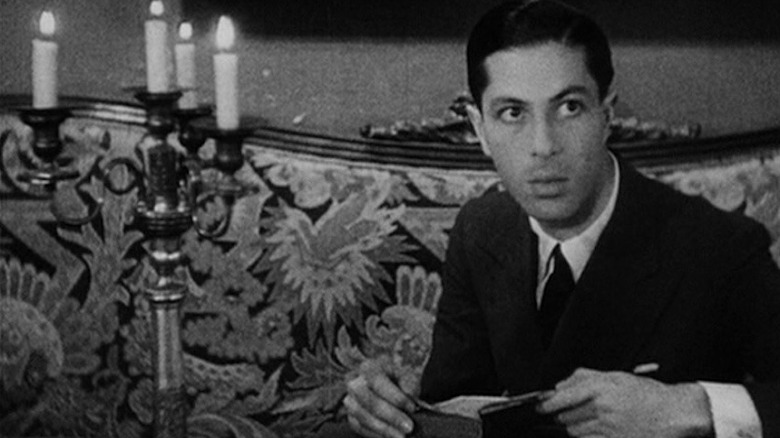 Allan Gray sitting on a sofa in "Vampyr"